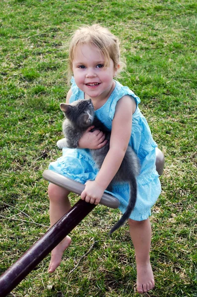 Child with cute kitten on a teeter totter — Stock Photo, Image