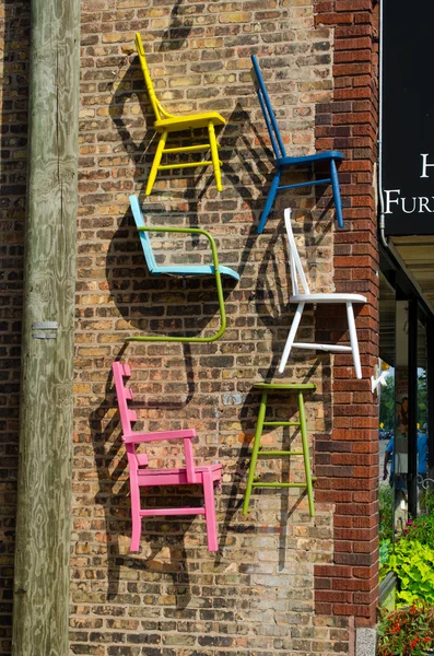 Colorful chair art on a brick wall