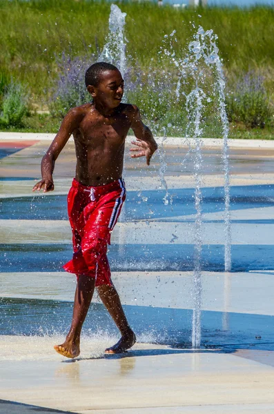 Junge kühlt sich im Stadtbrunnen ab — Stockfoto