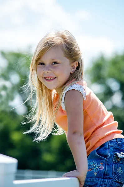 Schattig blond kind op hek — Stockfoto