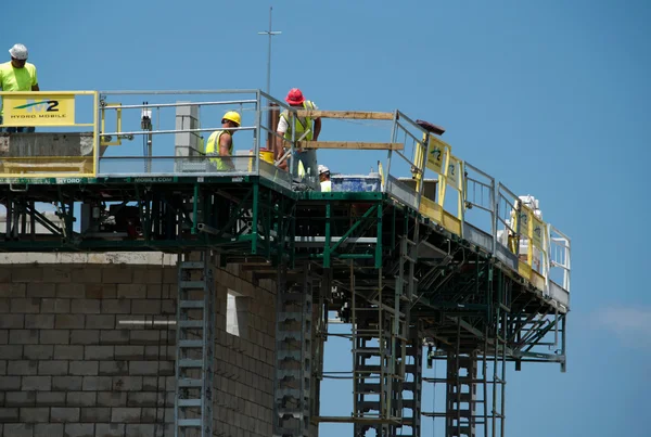 Bauarbeiter legen Ziegel auf ein Gebäude — Stockfoto