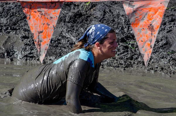 Woman crawls through mud to the finish line — Stock Photo, Image