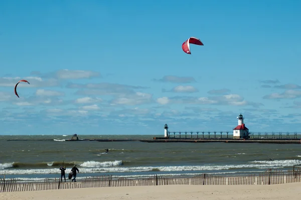 Kiteboardisty ve vodě a na pláži — Stock fotografie