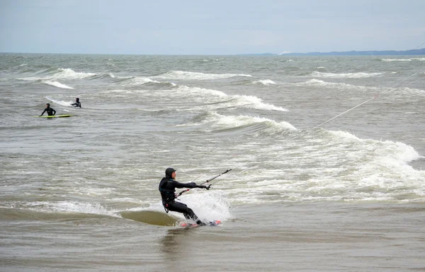 Kiteboarder und Surfer — Stockfoto