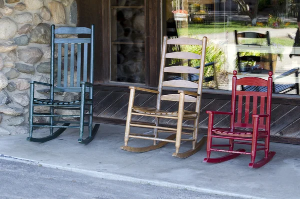 Tři houpací židle v různých barvách na veranda — Stock fotografie
