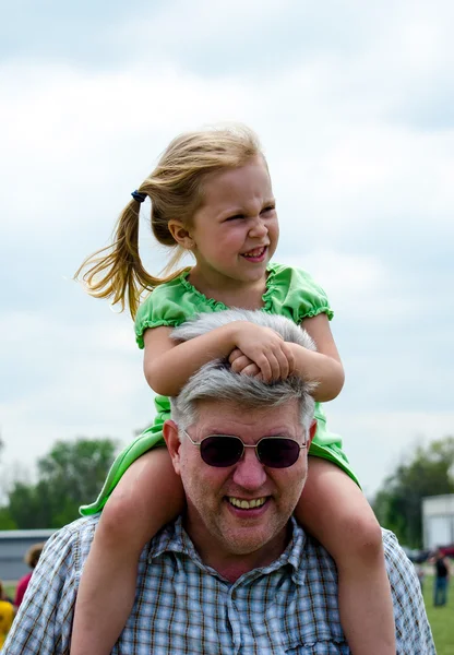 Girl on grandpas shoulders — Stock Photo, Image