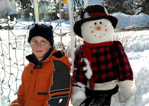 Liten pojke och snö man — Stockfoto