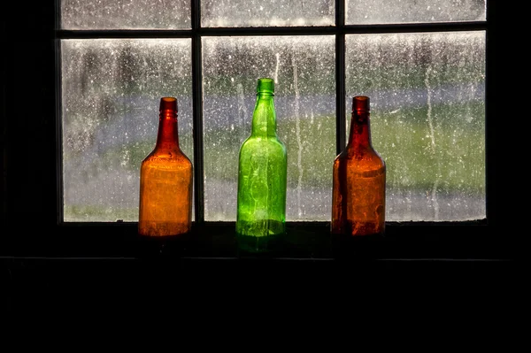 Botellas de colores en una ventana brillante — Foto de Stock