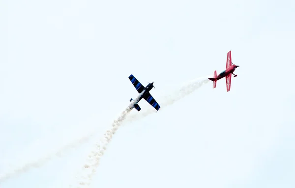 Aviões vermelhos e azuis voam em um show aéreo — Fotografia de Stock