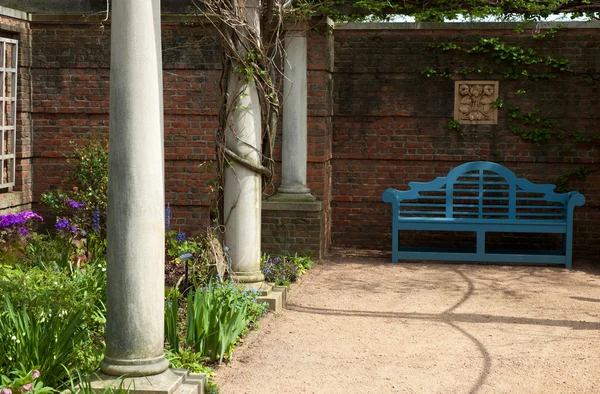 Banco azul em um jardim — Fotografia de Stock