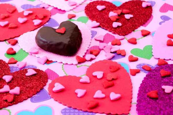 Chocolate and candy hearts on heart background — Stock Photo, Image