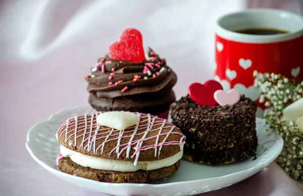 Doces extravagantes e uma caneca de café vermelha e branca — Fotografia de Stock