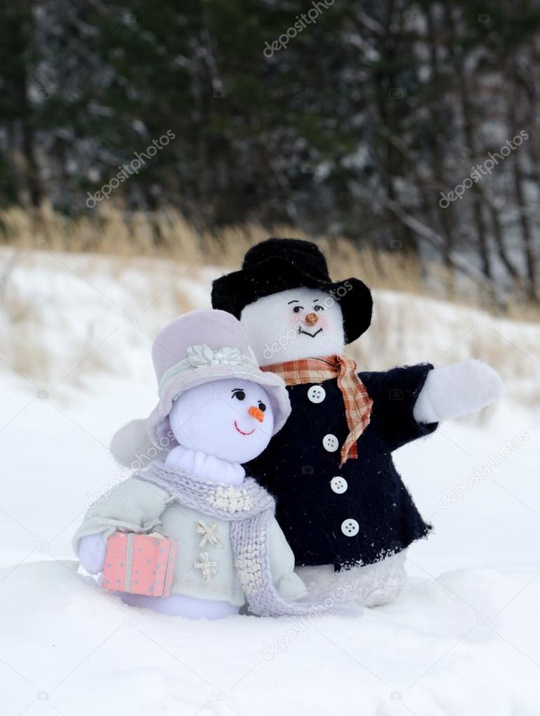 Snowman couple cuddle in the snow