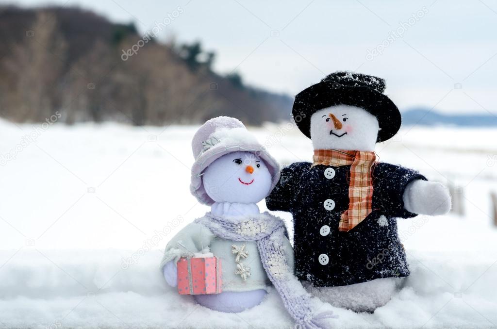 Snowman couple at the beach in winter
