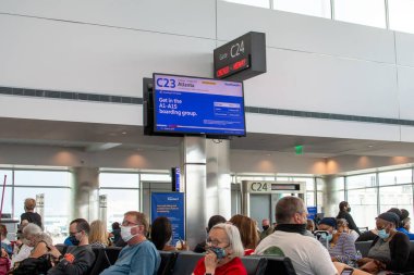 Aurora co USA 7 Haziran 2021, maskeli büyük bir grup Denver Uluslararası Havaalanı 'nda rötarlı uçuş bekliyor.