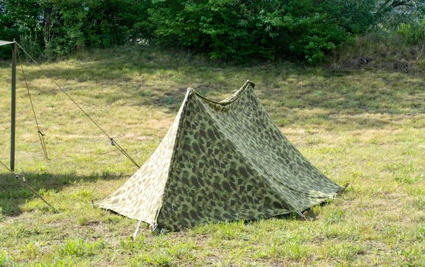 A small military tent is set up during a war reenactment event