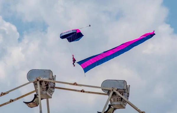 2019年7月10日ミシガン州の大急流アメリカ航空ショー中に飛行機からパラシュートと旗のある男が飛び立ち カーニバルに乗る — ストック写真