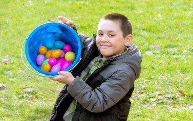 Happy boy shows how many easter eggs he found during the easter egg hunt