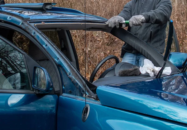 worker replaces a windshield in a car that had one that was broken
