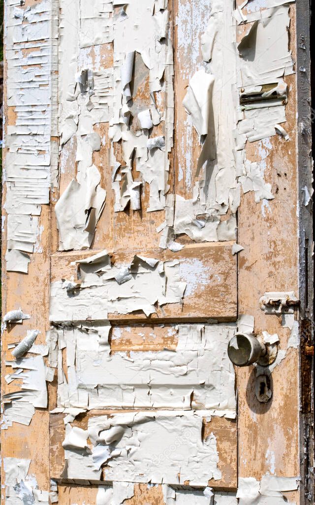 An old wooden door is covered in peeling paint