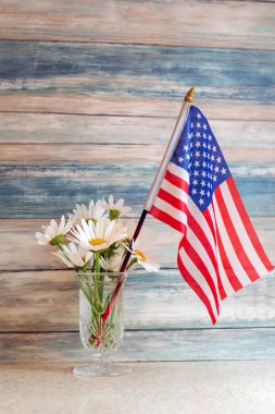 Sade beyaz papatyalar ve Amerikan bayrağıyla dolu kır hayatı, mavi ahşap arka planda