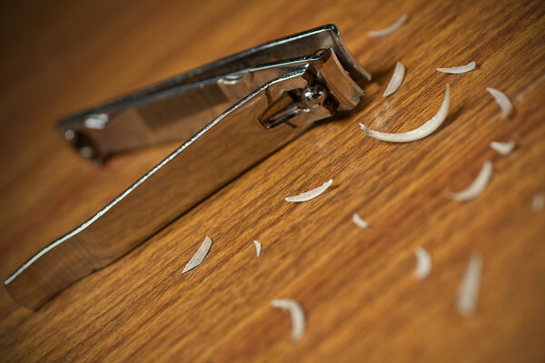 Грязные ногти и ножницы на деревянном столе
