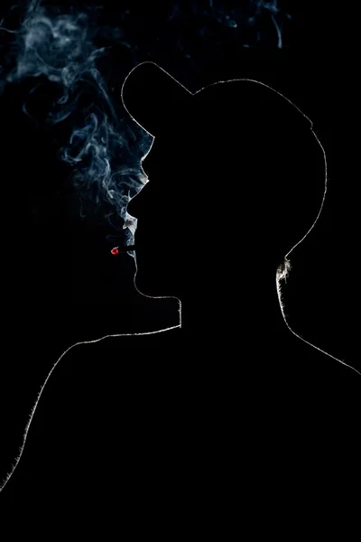 Jeune adulte Fumer une cigarette en silhouette — Photo