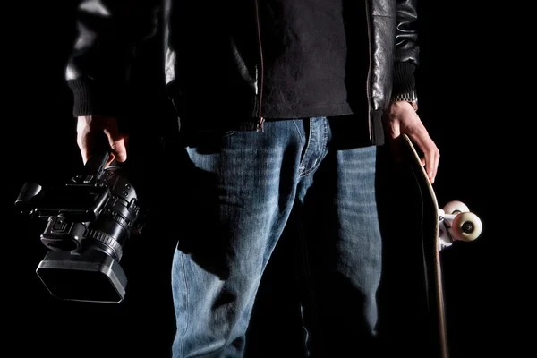 Skateboarder holding een videocamera en een skateboard — Stockfoto