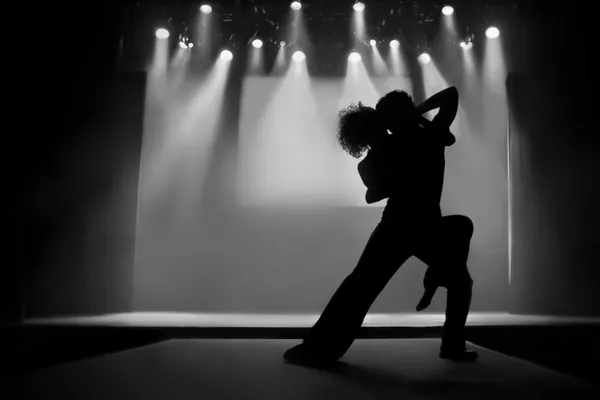 Casal em silhueta dançando em um palco — Fotografia de Stock