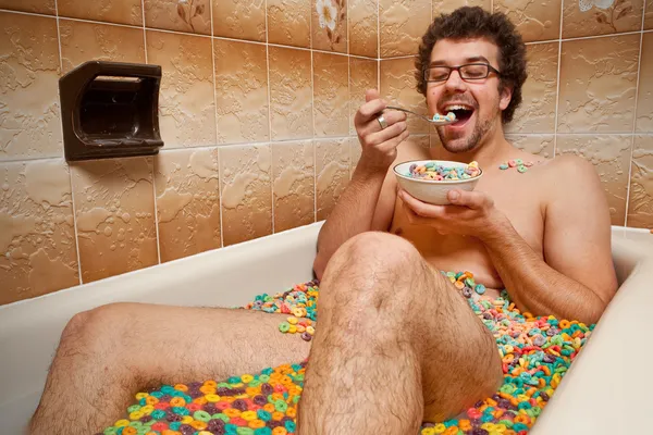Забавный человек ест свои хлопья в ванной — стоковое фото