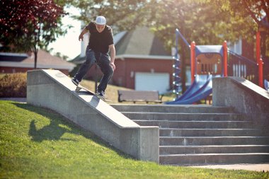 bir parkta frontside lipslide hile yaparak kaykaycı