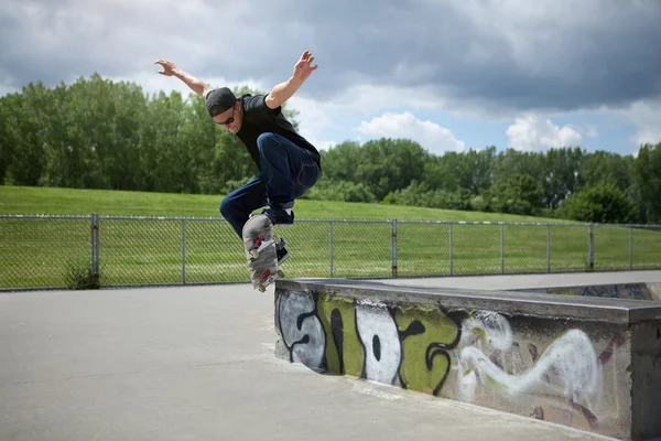 Skateboardåkare gör en wallie i en skatepark — Stockfoto