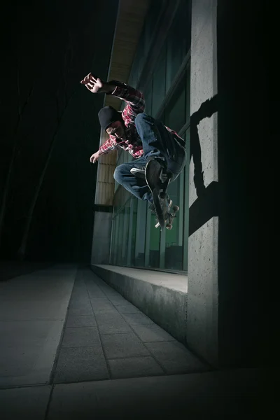 Skateboarder haciendo un Wallie en una pared Fotos de stock libres de derechos