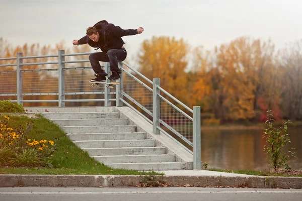 Skateboardåkare gör en ollie ner för trapporna Stockfoto