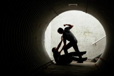 Young man being mugged in a dark tunnel clipart