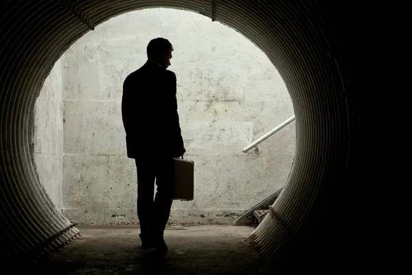 Businessman in Silhouette Walking in a dark tunnel — Stock Photo, Image