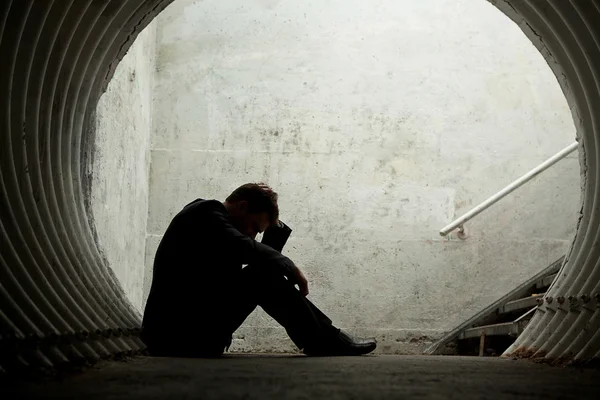 Desparate Businessman in silhouette lying on the ground Royalty Free Stock Images