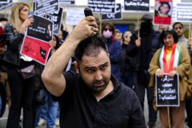 23 Eylül 2022 'de Mahsa Amini' nin ölümü üzerine Belçika 'nın Brüksel kentindeki İran Büyükelçiliği önünde düzenlenen gösteride bir adam saçını kesti..