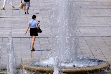 18 Ağustos 2022 'de Atina, Yunanistan' ın merkezinde sıcak bir günde insanlar sokaklarda yürüyor.