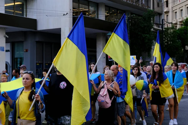 2022年8月24日 居住在希腊的乌克兰人和示威者在雅典举行的庆祝乌克兰人独立日的集会上举着乌克兰国旗和标语 — 图库照片