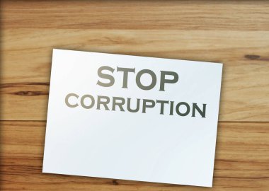 Sayfadaki Yolsuzluk Sözcükleri 'ni ve ahşap masadaki kağıt para işaretlerini durdurun. Yolsuzlukla mücadele konsepti.