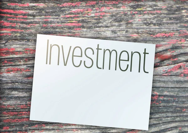 Інвестиційне слово на сторінці і знаки паперового долара навколо дерев'яного столу. Концепція фінансового бізнесу — стокове фото