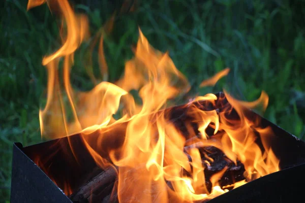 たき火の灰をほこります 火はキャンプファイアで燃え尽きる — ストック写真