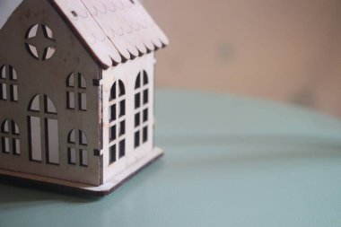 Naneli masada tahta oyuncak ev var. Ev sigortası konsepti. Emlak işi kavramı.