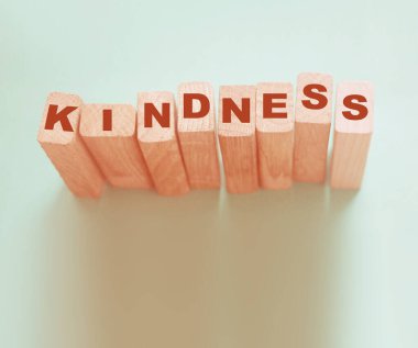 KINDNESS kelime ahşap yapı taşları ile yapılmış neon aquamarine arkaplan.