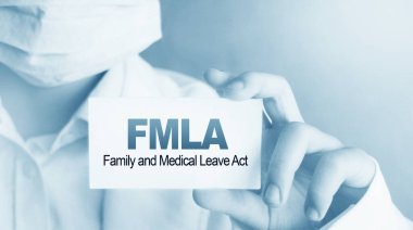 Doktor elinde FMLA tıbbi konsepti olan bir kart tutuyor..