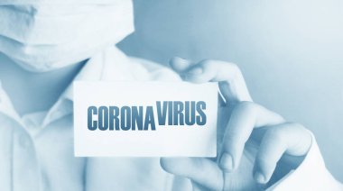 Coronavirus 'un yazılı olduğu tıbbi personel kartı. CoVid-19 pandemik alarm karantina kavramı.
