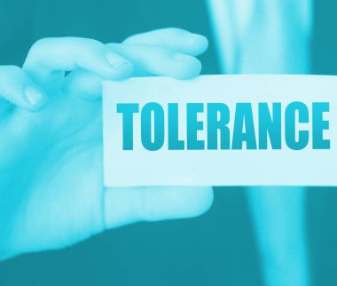 İş adamının elindeki bir kartta hoşgörü sözcükleri. İş yerinde ayrımcılığa karşı sosyal konsept.