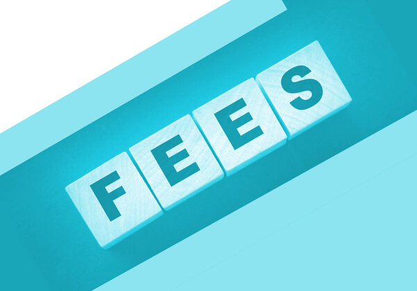 Wooden blocks with the word Fees . Taxes and fees business concept.