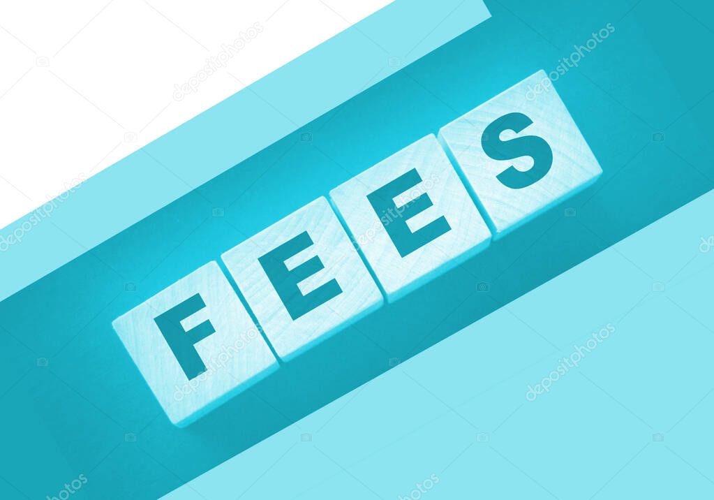 Wooden blocks with the word Fees . Taxes and fees business concept.
